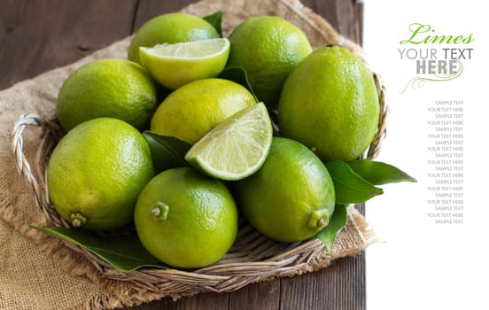 Fresh limes in a basket on a wooden table