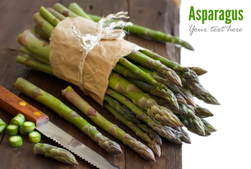 Fresh asparagus with knife on a wooden table