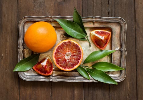 Fresh red oranges on a tray on a wooden table