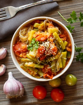 Rice spaghetti with vegetables in a bowl top view