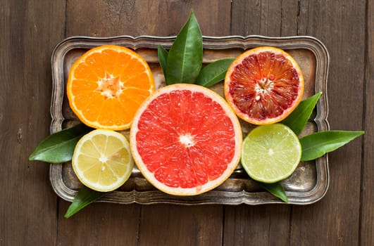 Fresh citrus fruits with leaves on a wooden table top view