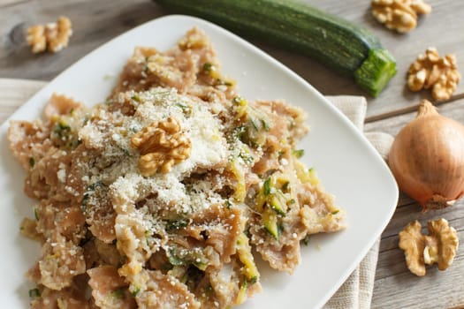 Wholegrain Pasta with topinambur cream, walnuts and zucchine on wood