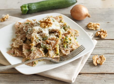Wholegrain Pasta with topinambur cream, walnuts and zucchine on wood