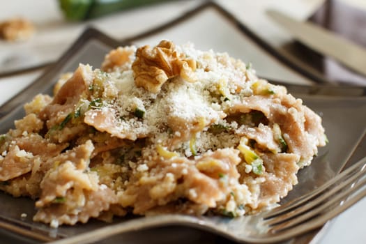Wholegrain Pasta with topinambur cream, walnuts and zucchine closeup