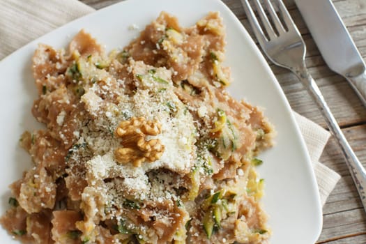 Wholegrain Pasta with topinambur cream, walnuts and zucchine on wood
