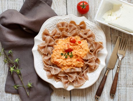 Wholegrain Pasta with stracchino cheese and fresh tomatoes top view