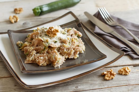 Wholegrain Pasta with topinambur cream, walnuts and zucchine on wood