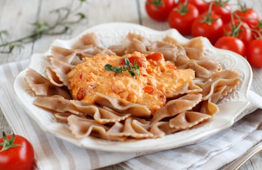 Wholegrain Pasta with stracchino cheese and fresh tomatoes close up