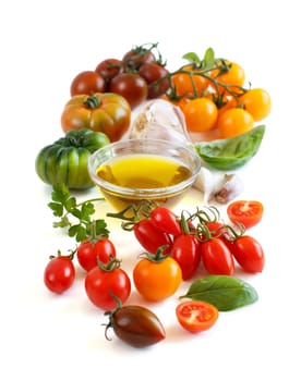 Colorful tomatoes, garlic, herbs and oilve oil isolated on white