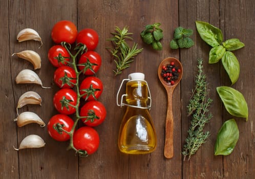 Vegetables, herbs and olive oil on wooden background