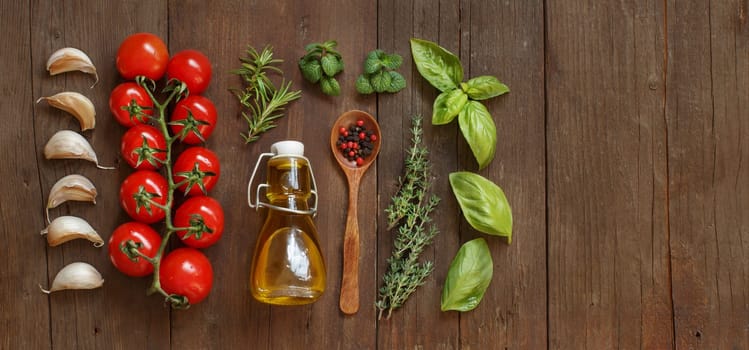 Vegetables, herbs and olive oil on wooden background