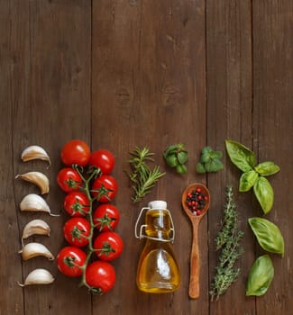Vegetables, herbs and olive oil on wooden background