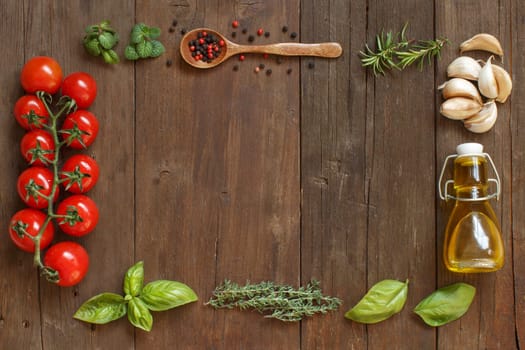 Vegetables, herbs and olive oil on wooden background