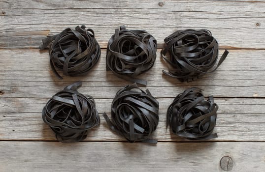 6 Black tagliatelle on an old wooden table