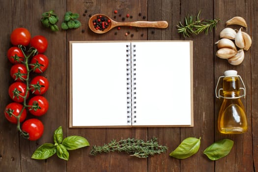 Craft paper with border of vegetables, herbs and olive oil on wooden background