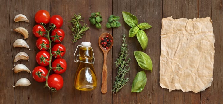 Vegetables, herbs and olive oil with craft paper on wooden background
