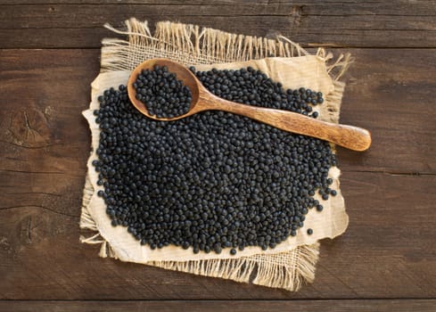 Pile of Black Lentils with a spoon top view