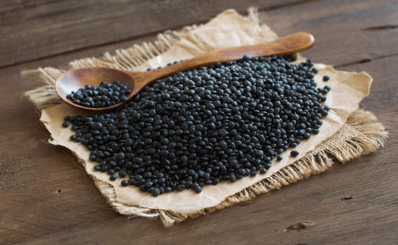 Pile of Black Lentils with a spoon top view