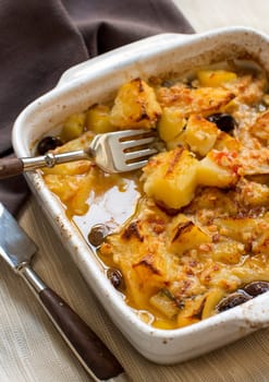 Fish with potatoes and olives cooked in oven in small casserole