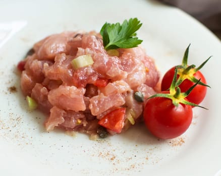 Delicious raw tuna tartare decorated with cherry tomatoes