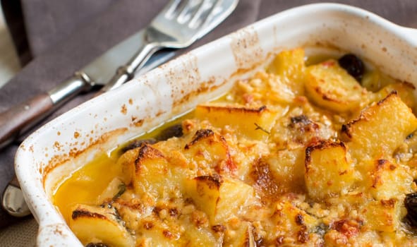 Fish with potatoes and olives cooked in oven in small casserole
