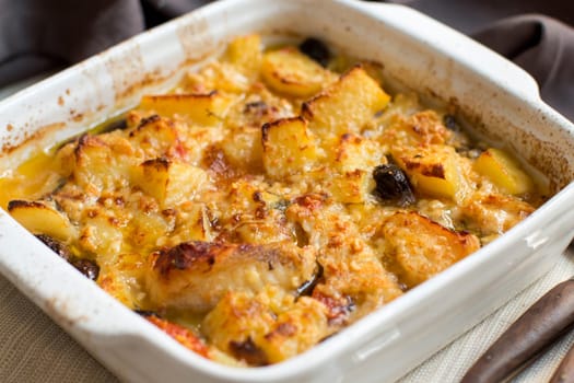 Fish with potatoes and olives cooked in oven in small casserole