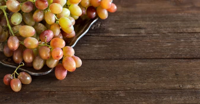 Grapes on silver tray on an Old Wooden Background