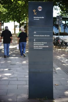 Bremen,Germany - August 30,2016: Walkers at a sign and a trail marker in front of the old town on August 30,2016 in Bremen.