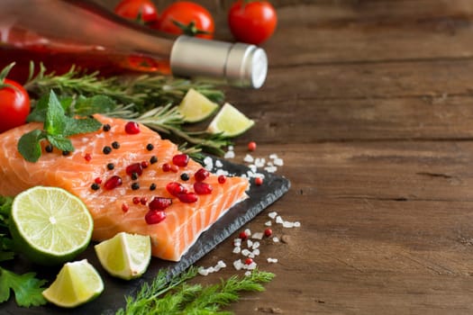 Salmon with vegetables, olive oil and herbs on wood