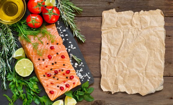 Salmon with vegetables and herbs on wooden background