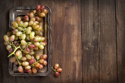Grapes on silver tray on an Old Wooden Background