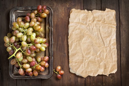 Grapes on silver tray on an Old Wooden Background