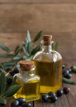 Olive oil and olives on rustic wood background