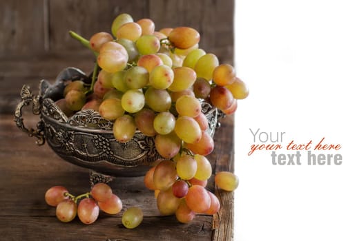 Grapes in silver bowl on an Old Wooden Background