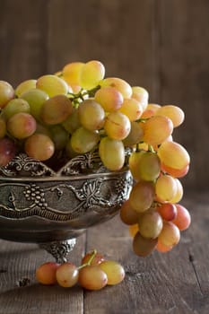 Grapes in silver bowl on an Old Wooden Background