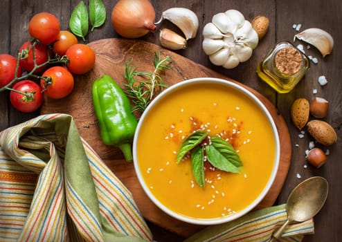 Fresh pumpkin soup and vegetables on a wooden table