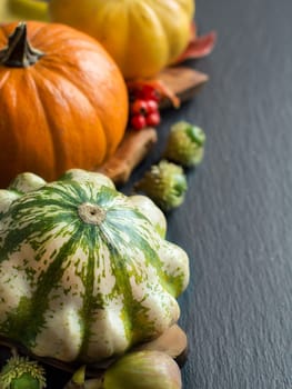 Pumpkins, acorns, leaves and berries on dark background