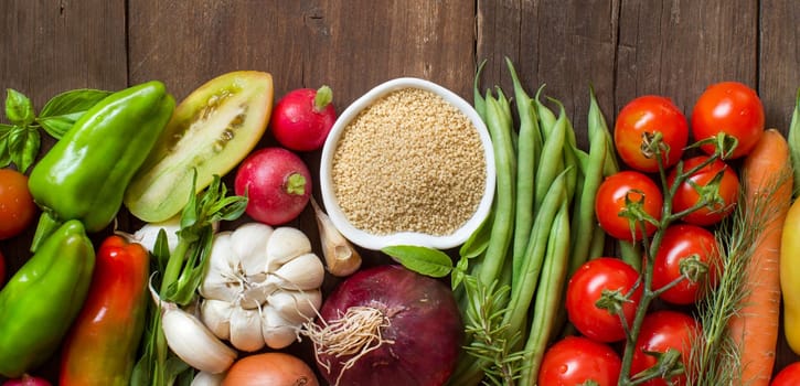 CousCous in a bowl and fresh vegetables on wood