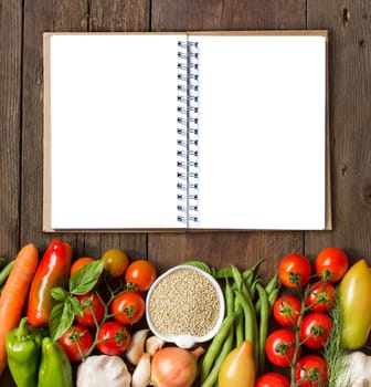 Quinoa, notebook and fresh vegetables on a wooden table