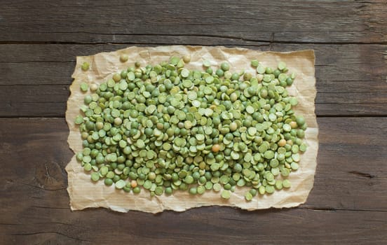 Dried Green Split Peas on a craft paper on wood