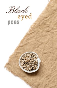 Black eyed peas in a bowl on burlap top view