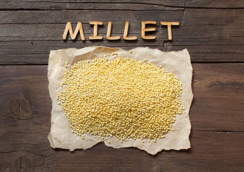 Raw millet on a craft paper with a word Millet