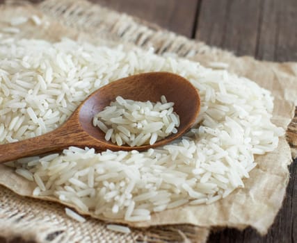 Basmati rice with a spoon on an dark wood