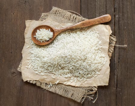 Basmati rice with a spoon on an dark wood