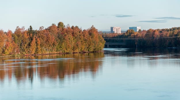 Umea, Sweden and its River in Fall with pair of buildings.