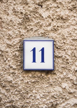 Ceramic number eleven on the grey stone wall