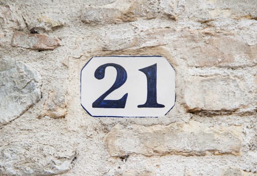 Ceramic number twenty one on the grey stone wall