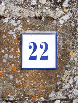 Ceramic number twenty two on the grey stone wall