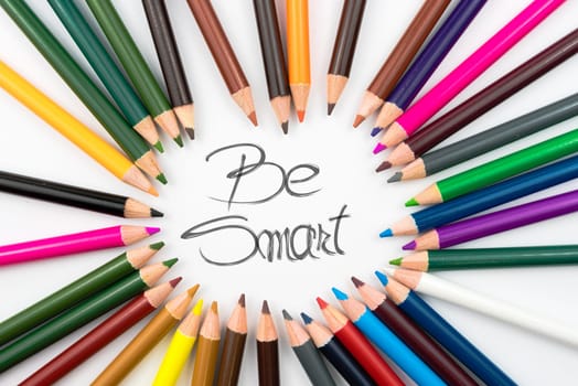 Colouring pencils in circle arrangement with message Be Smart, education concept