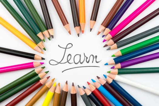 Colouring pencils in circle arrangement with message Learn, education concept